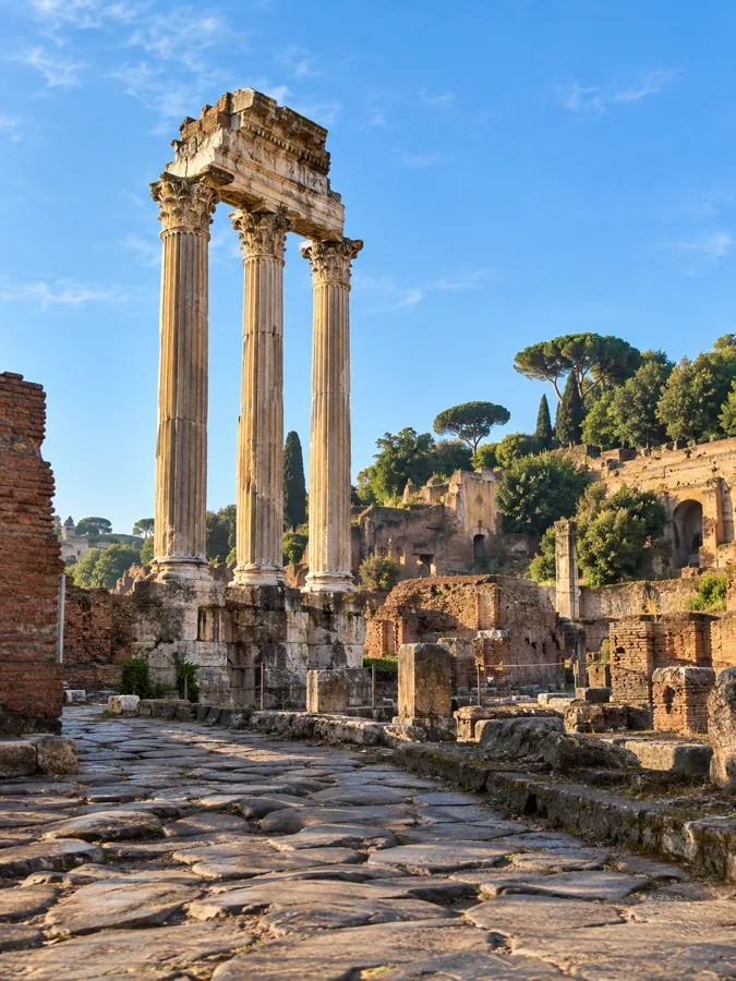 Drei stehende Marmorsäulen im Forum Romanum vor blauem Himmel
